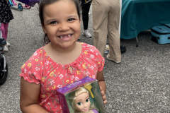 You young girl smiles holding a doll