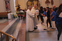A line of people processing to the alter in a Church where they are receiving a gift from a priest.