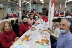 Members of the Catholic Charities Ozone Park Older Adult Center sit down for a Christmas Day meal in community,.