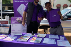 A couple of men standing next to a purple table.